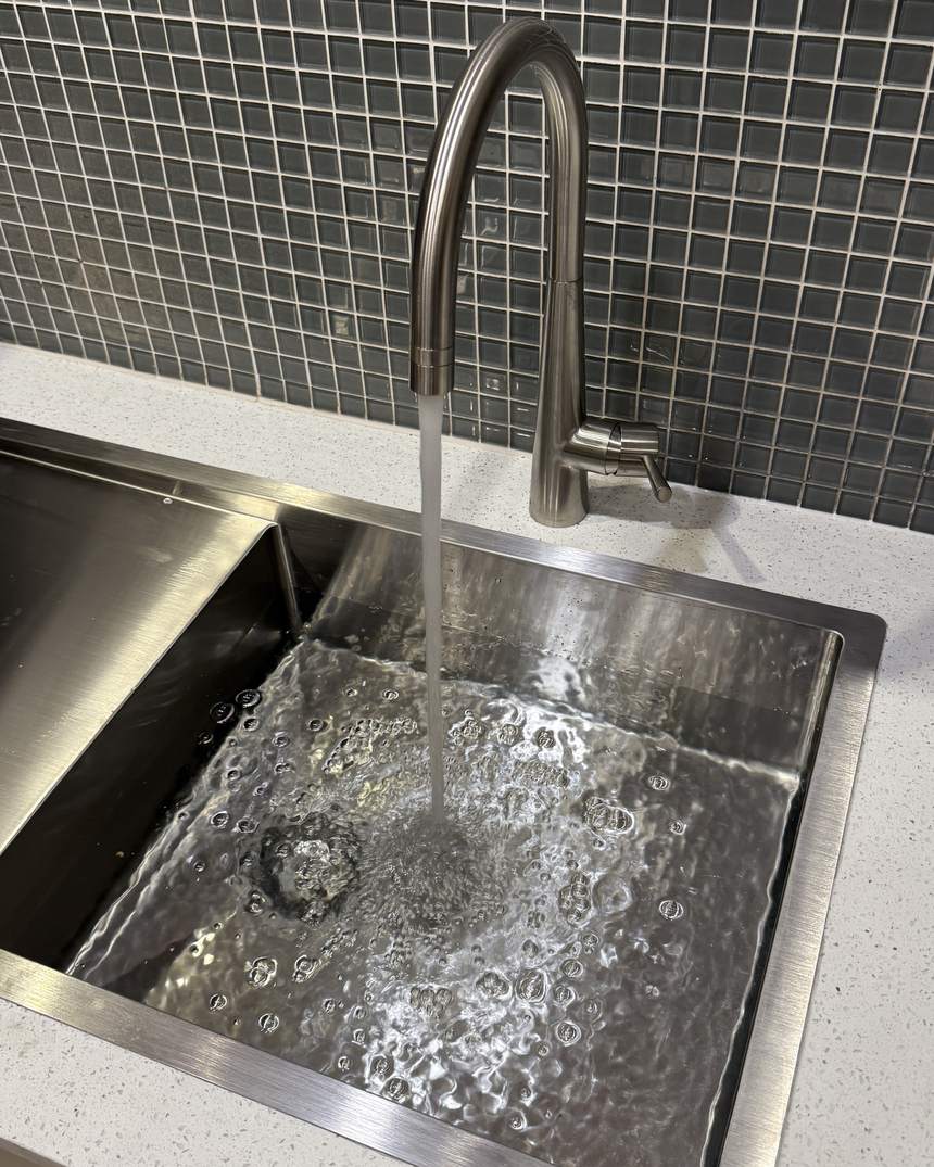 Clean filtered water running from a kitchen tap after a Maximise Plumbing filtration install
